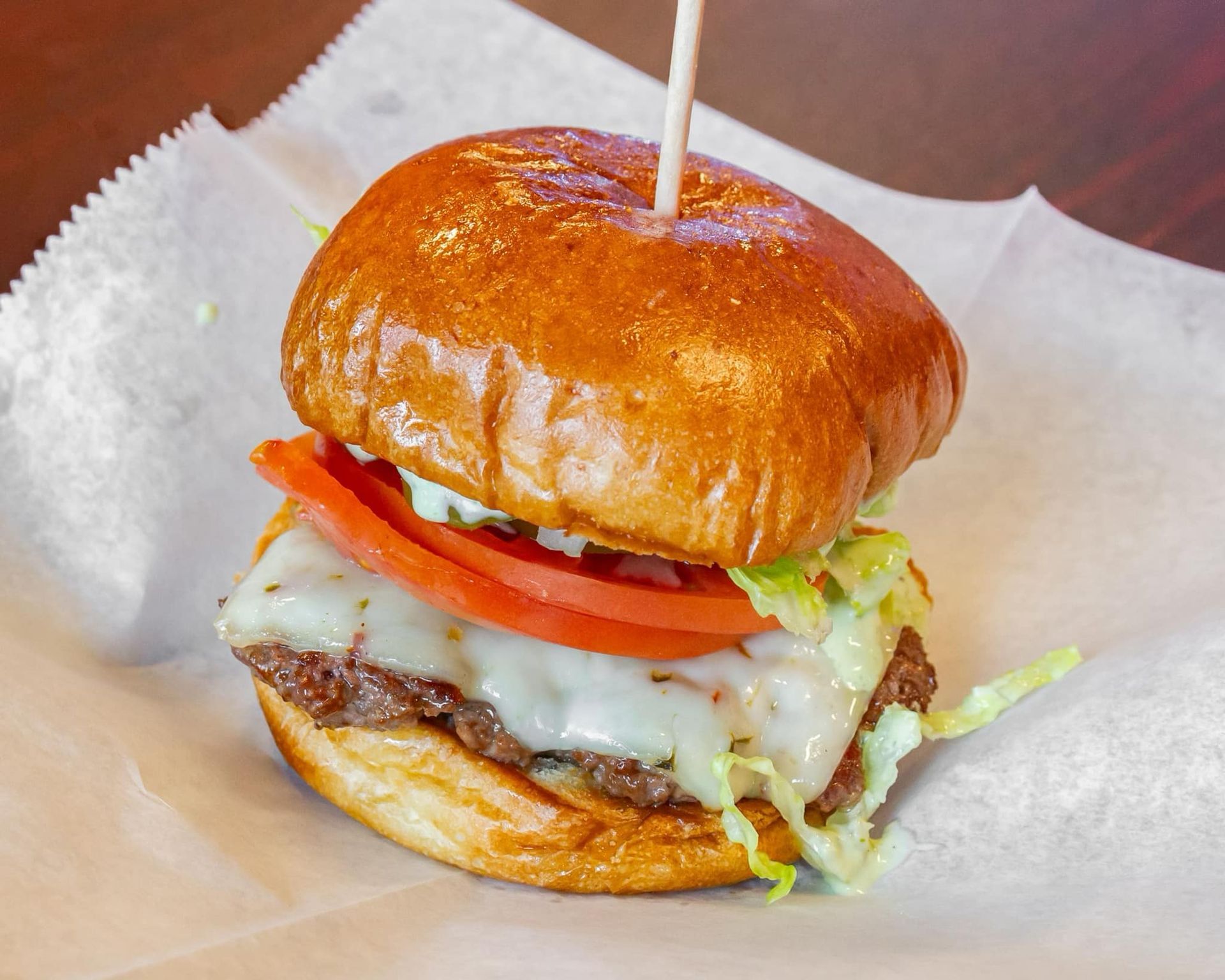 A hamburger with lettuce tomato and cheese on a bun