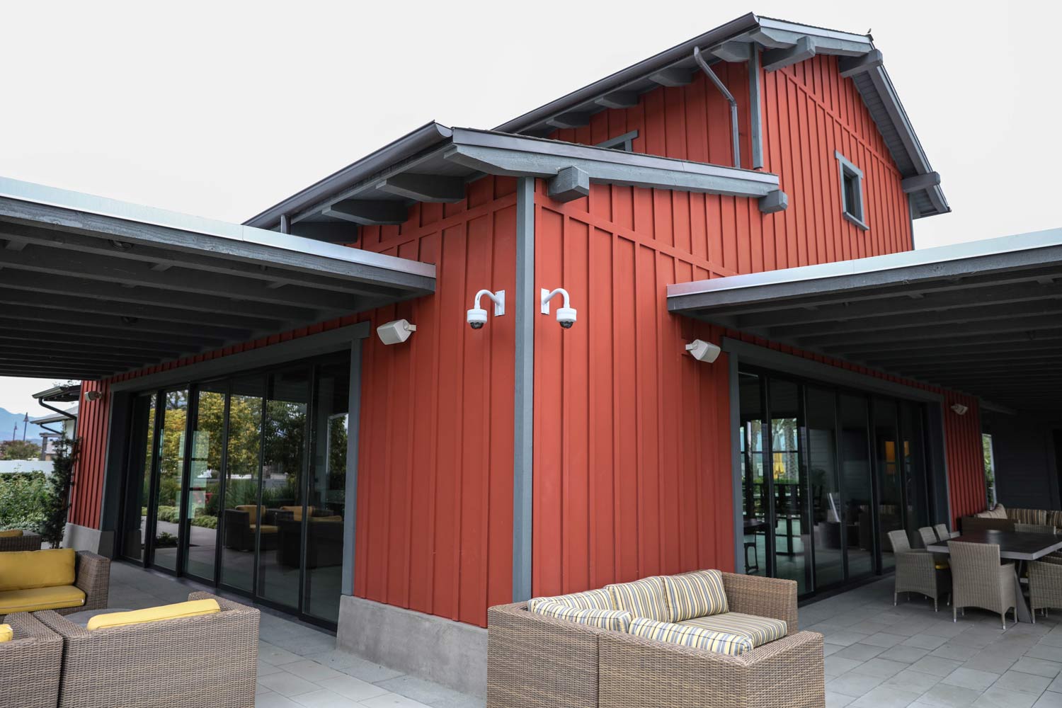 Red barn-style building with covered patio and glass windows
