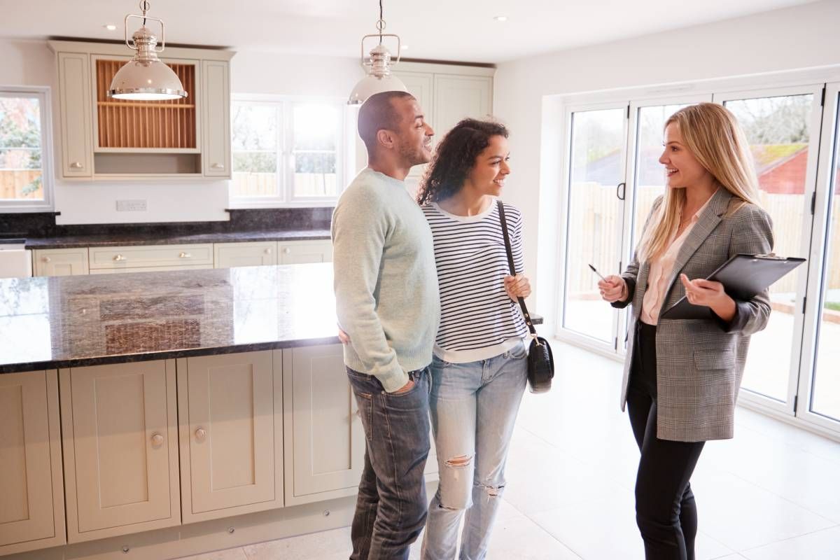 A realtor talking to two interested clients about a home at Kentuckiana Real Estate Academy near Kentucky, Indiana, and Ohio