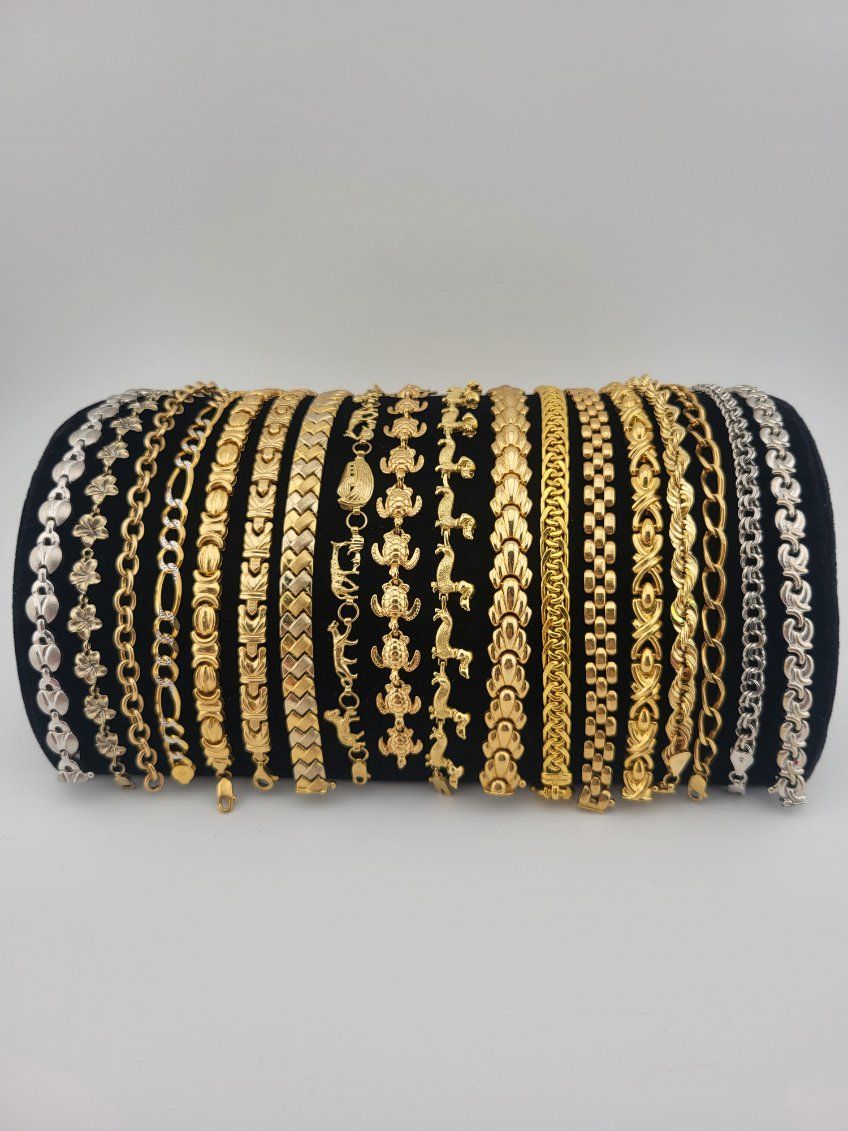 Stack of black and gold beaded bangles arranged in a cylindrical pile on a white background