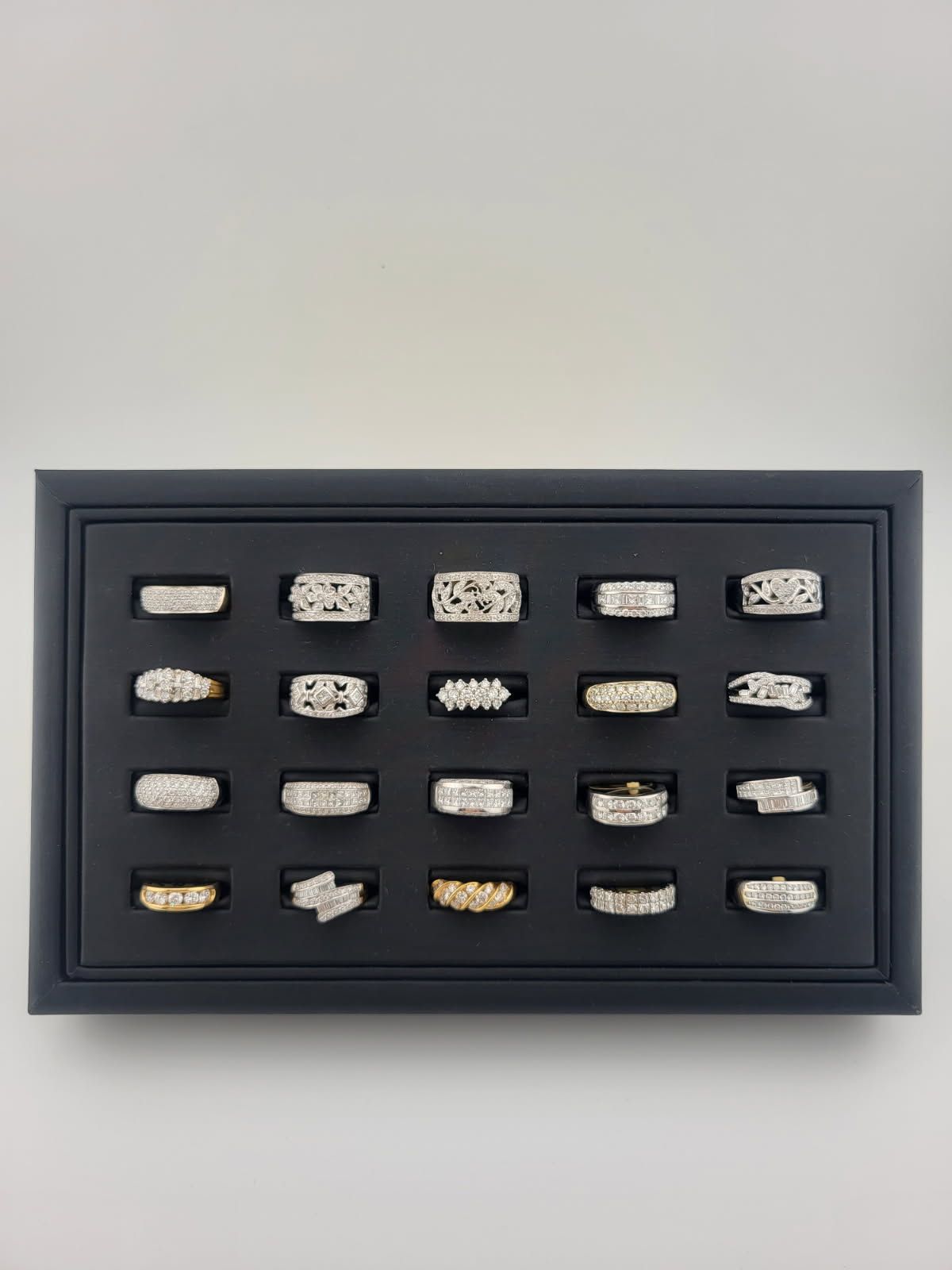 Framed display of 20 assorted small sample pieces on a dark background.