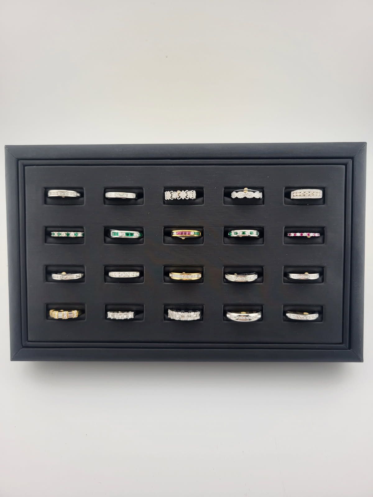 Framed display of assorted tiny model cars arranged in rows on a black background