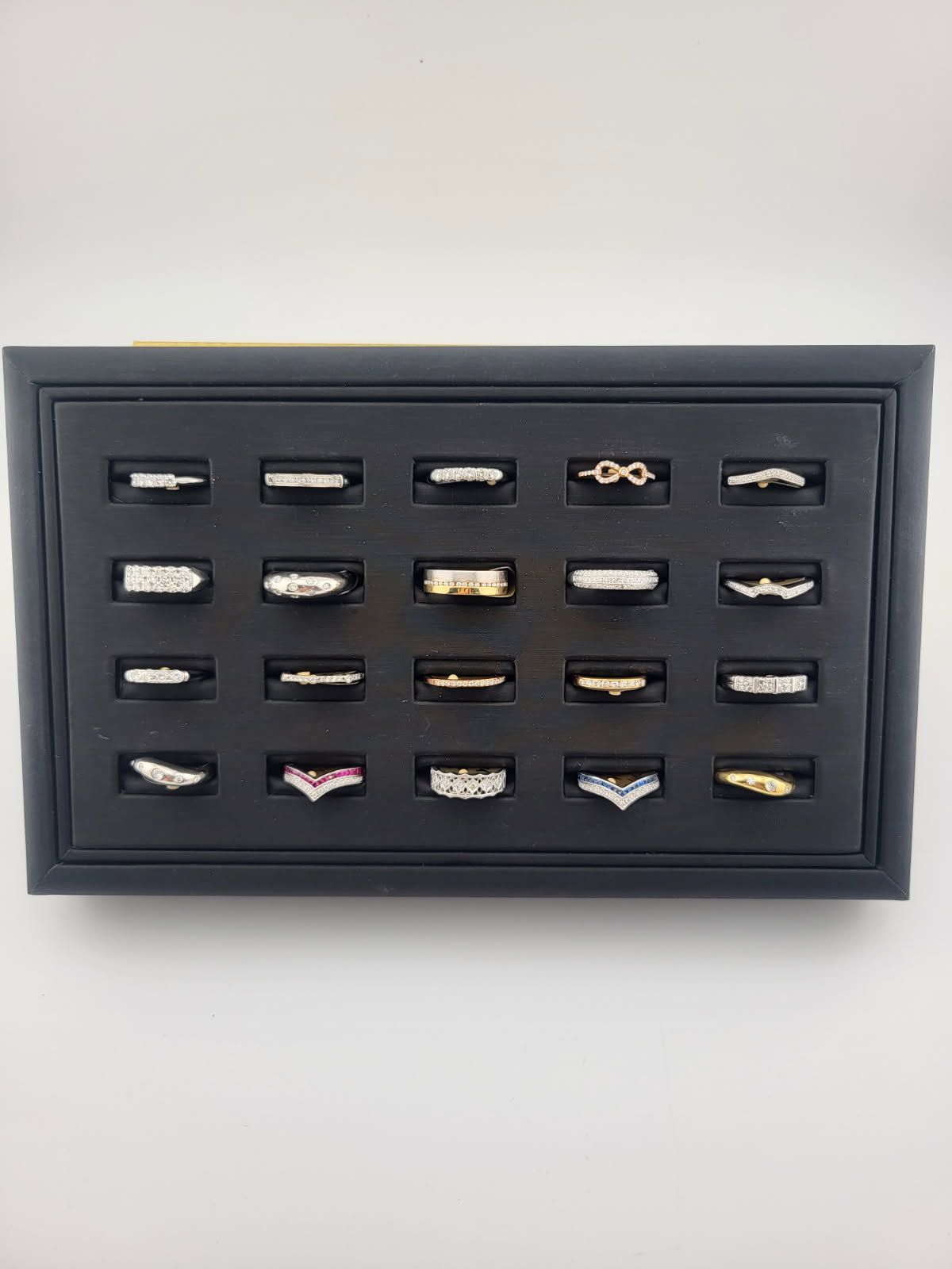 Framed display of many tiny beige-and-black rectangular pieces on a dark background