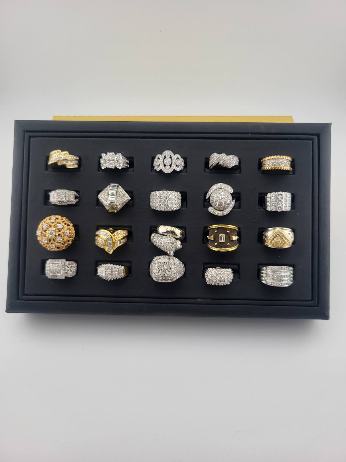 Black framed display of assorted metal rings on a light background