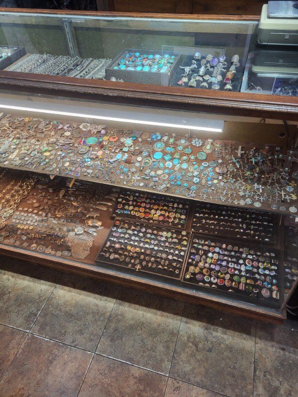 Glass display case filled with colorful rings and trinkets in a shop