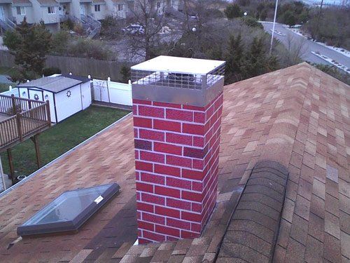 A red brick chimney is on the roof of a house