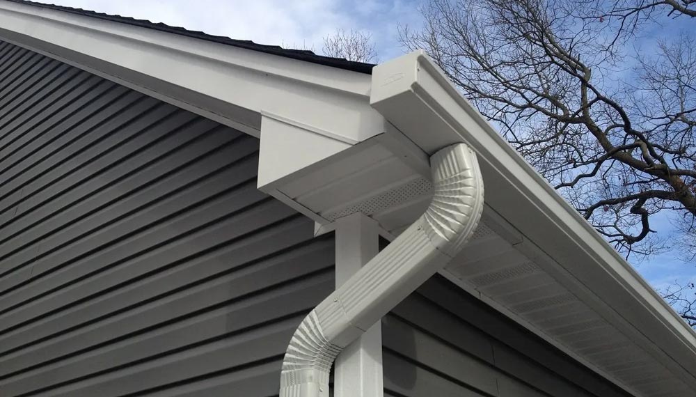 A white gutter on the side of a house