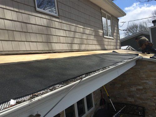 A man is working on the roof of a house.