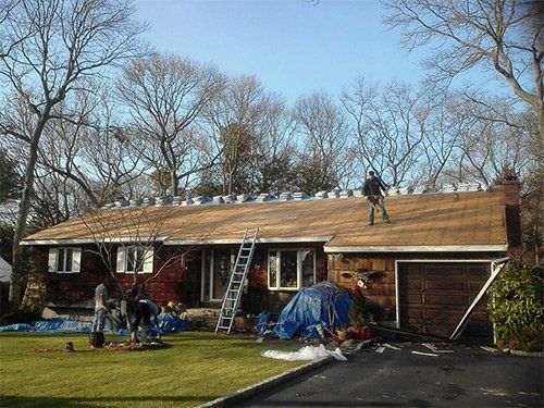A man is working on the roof of a house.