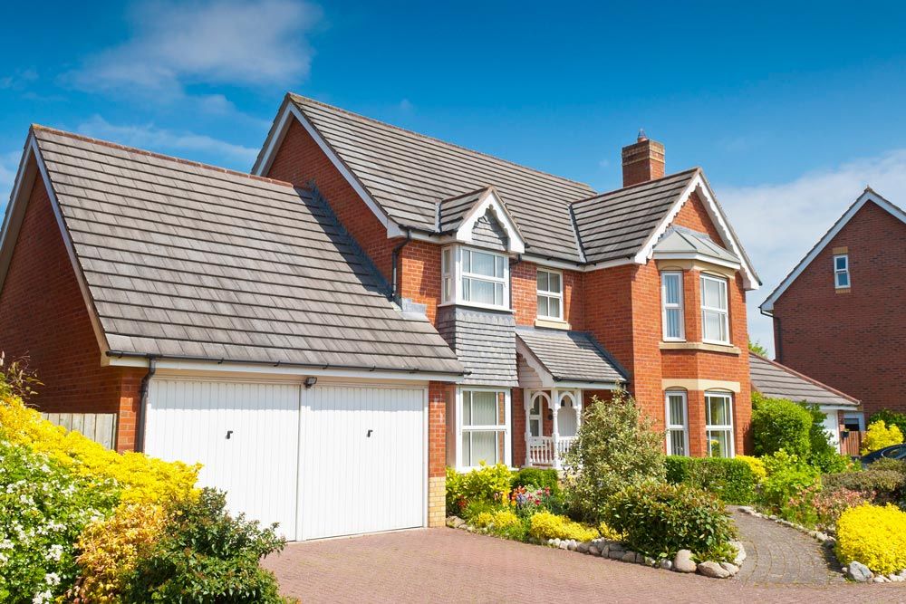 A large red brick house with a white garage door