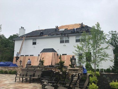 A large white house with a roof that is being repaired