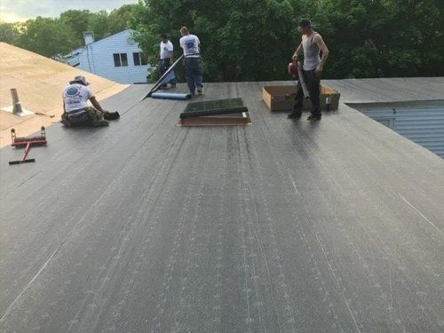 A group of men are working on a roof.