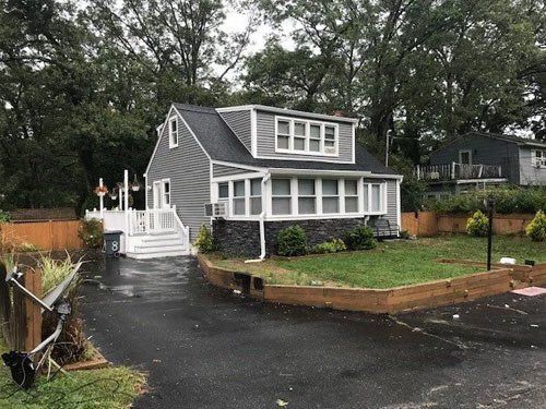 A house with a lot of windows and a driveway in front of it.