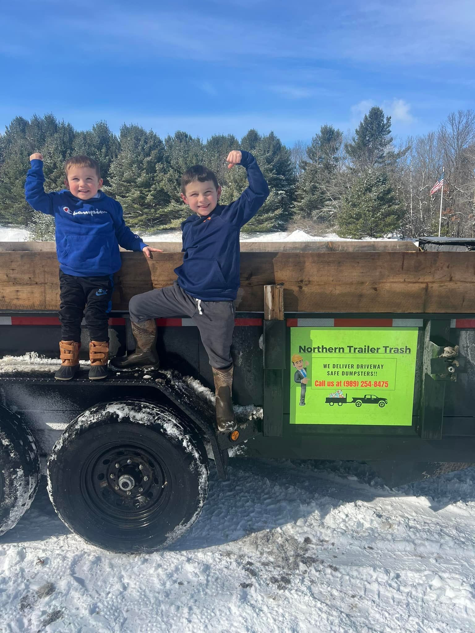 Two boys on a trailer, arms raised in a 