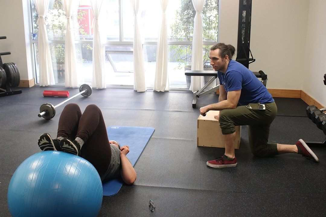 A man and a woman are doing exercises in a gym.
