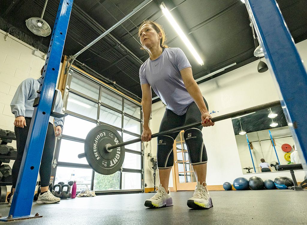 A woman in a black shirt is standing next to a man in a white shirt in a gym.