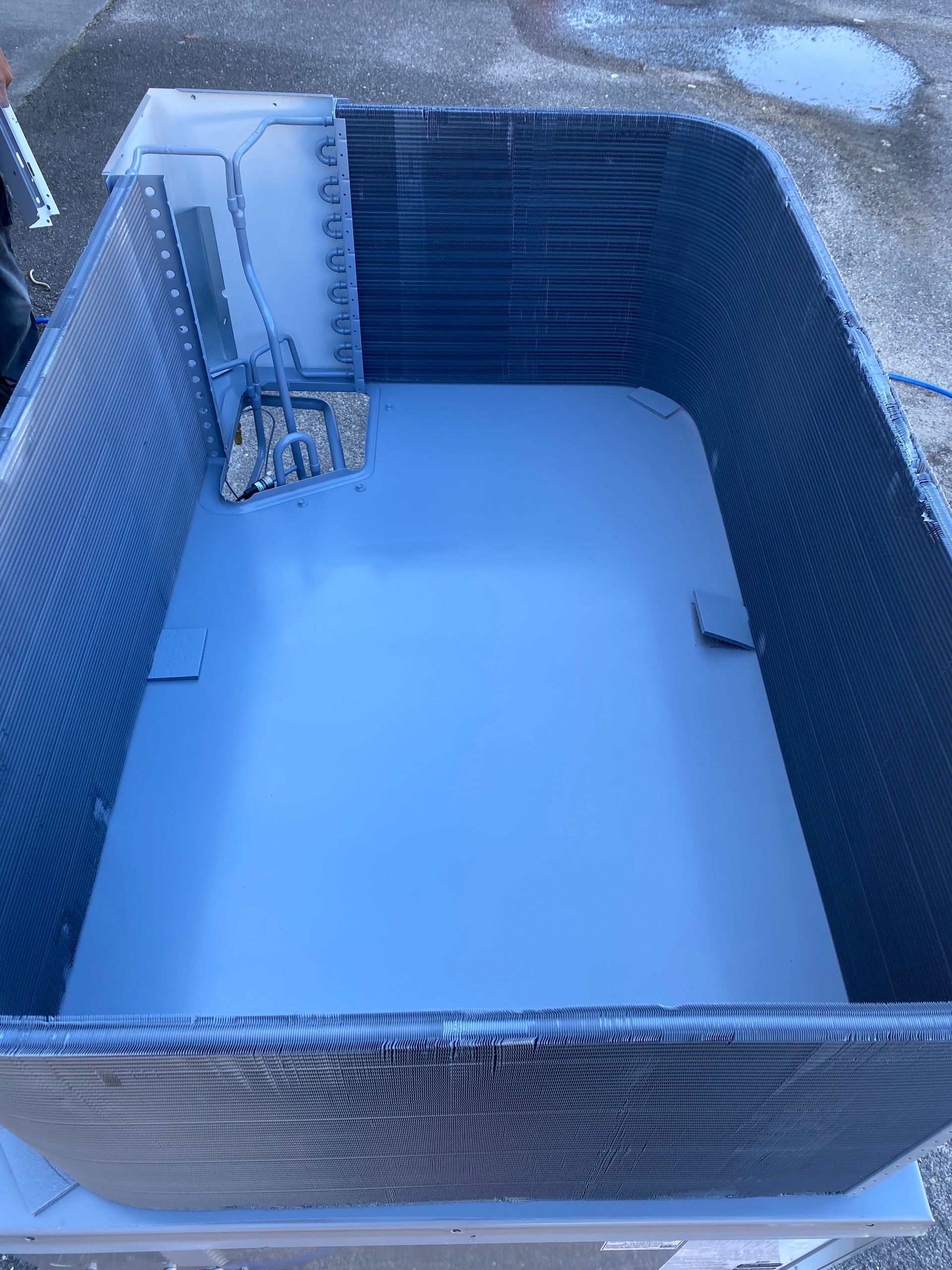 The internal components of an industrial HVAC unit are shown, featuring wiring, circuit boards, and a grey compressor.