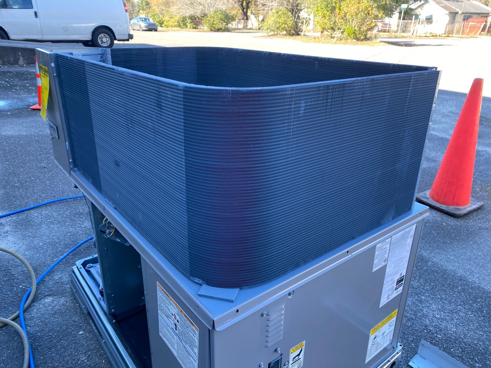 A blue air conditioner condenser coil and internal copper piping mounted on a wooden pallet.