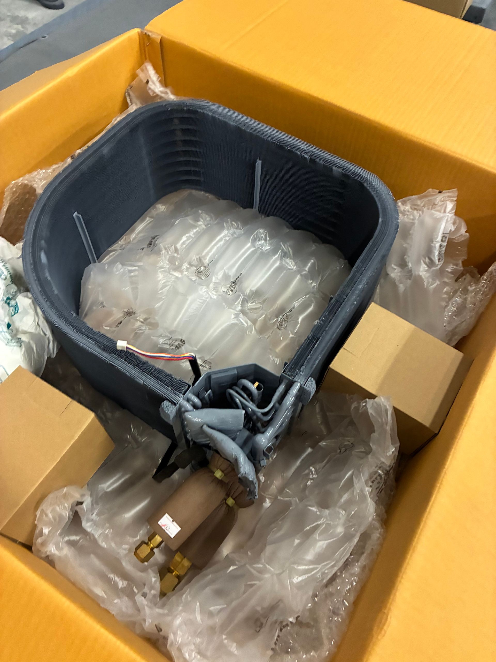 The internal components of an industrial HVAC unit are shown, featuring wiring, circuit boards, and a grey compressor.