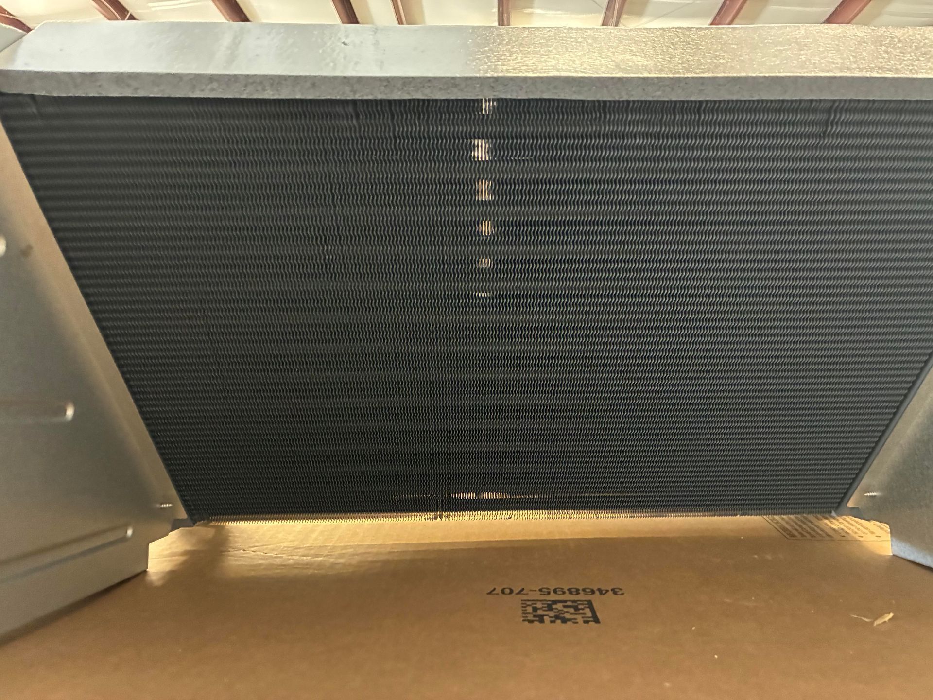 An open HVAC unit cabinet showing two grey vertical compressors connected by pipes and wiring against a metal frame.