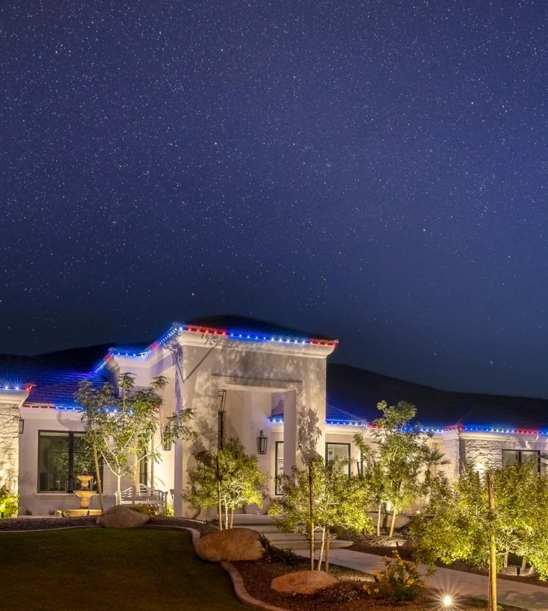 House at night with blue and red lights on roof and stars in the sky.