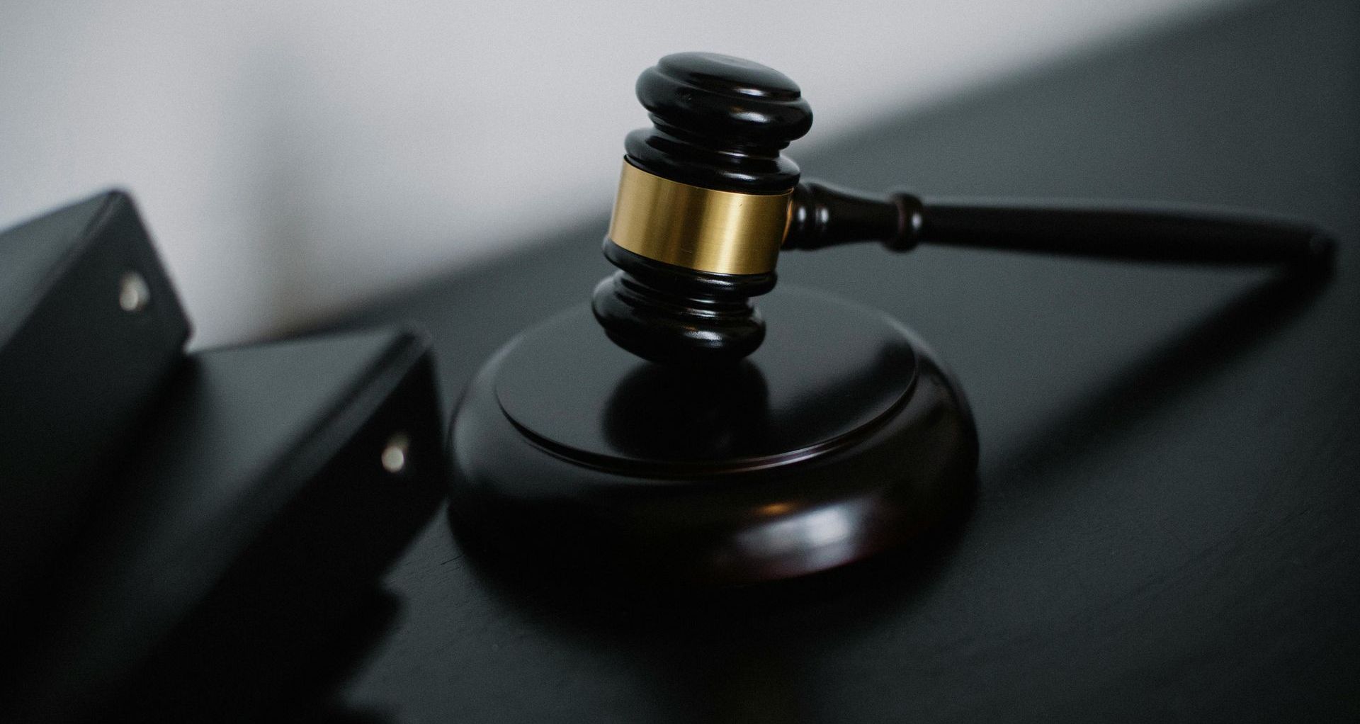 A judge 's gavel is sitting on top of a black table.