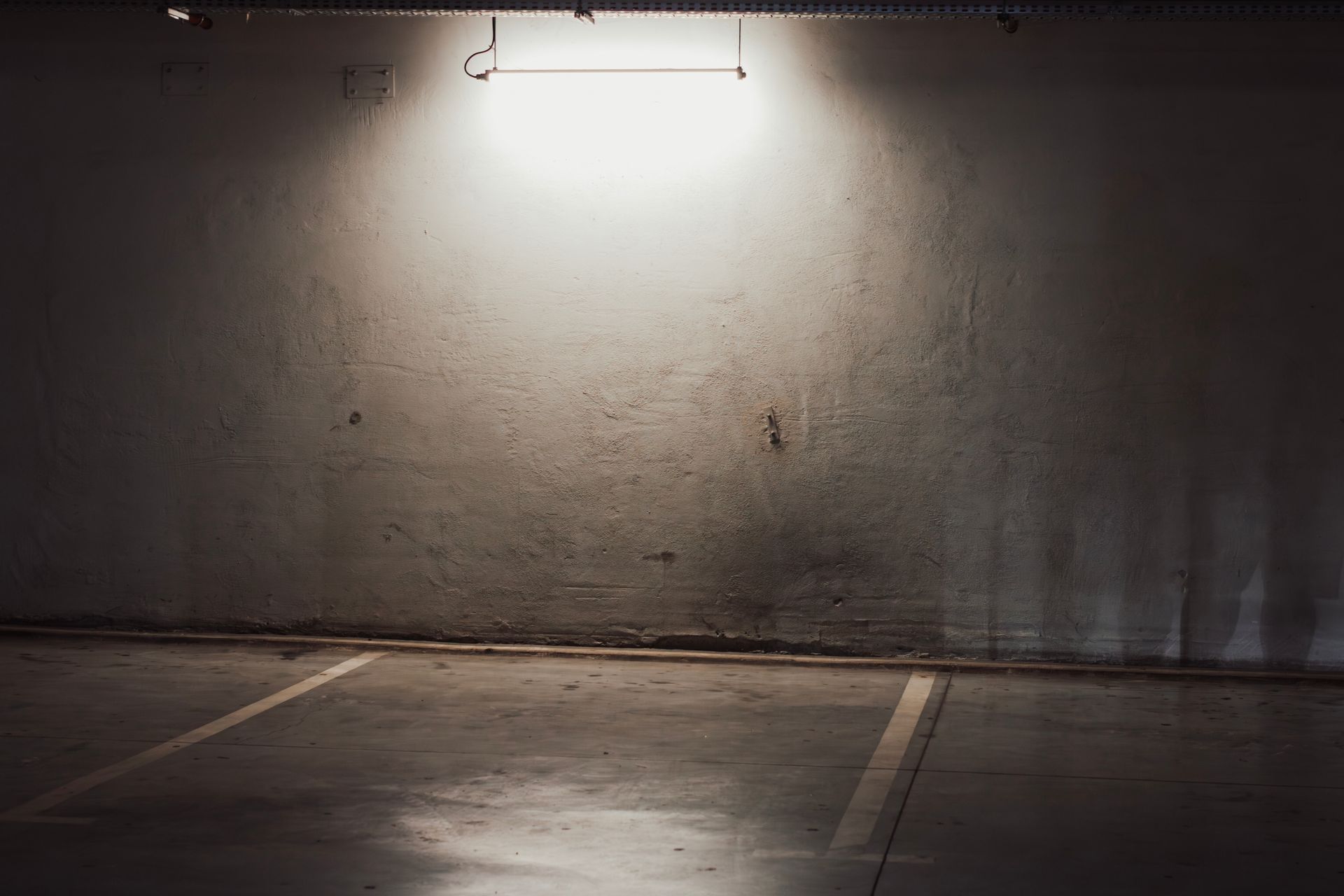 An empty parking garage with a light on the wall.