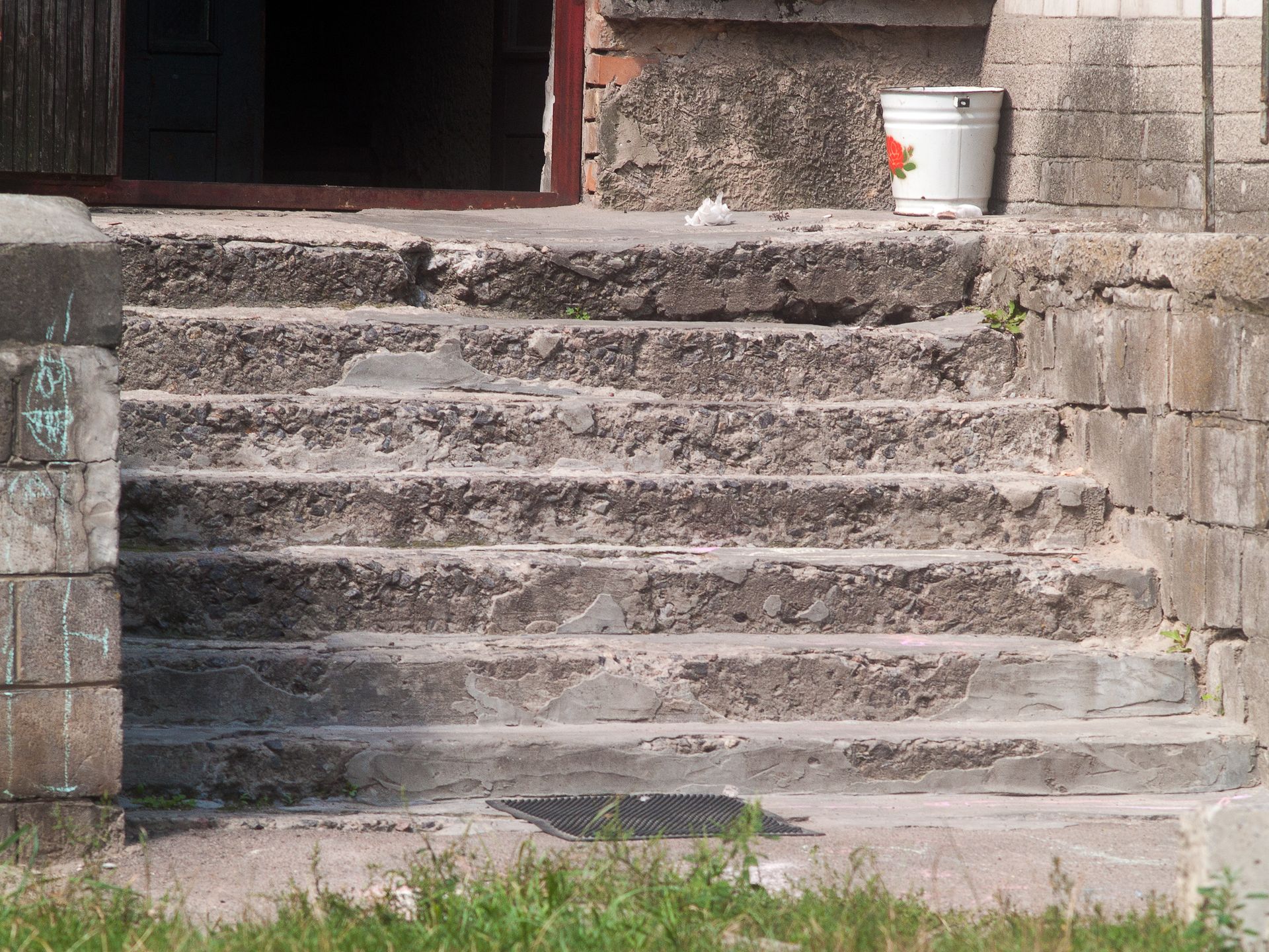 A staircase with a bucket on the side of it