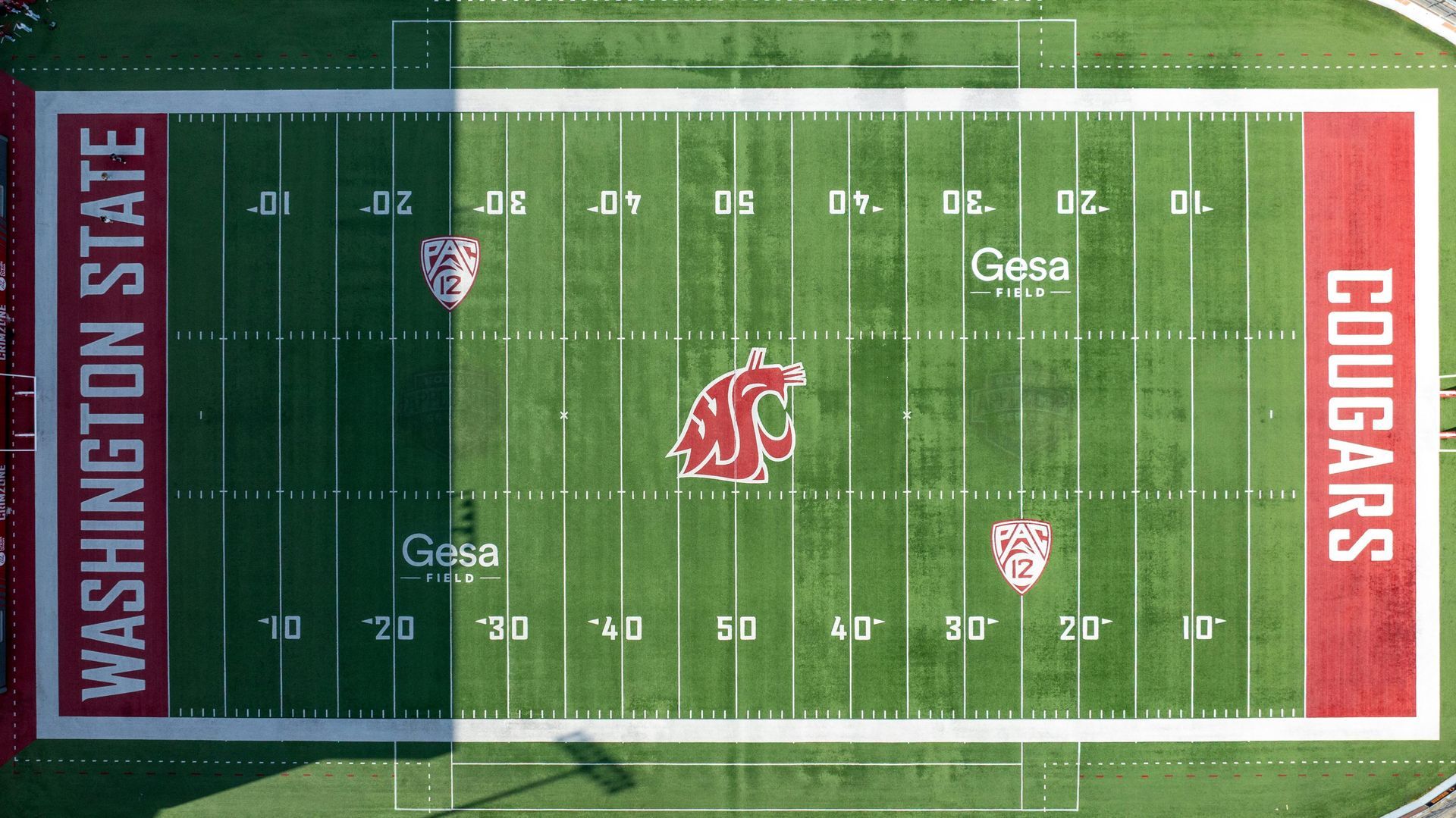 Aerial view of a Washington State Cougars football field with red end zones and midfield logo