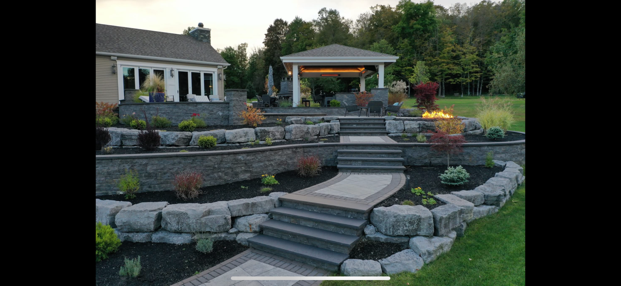 A large backyard with a gazebo and stairs leading up to it.