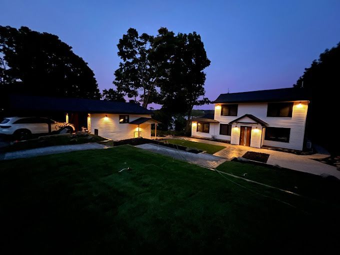 A house with a car parked in front of it at night