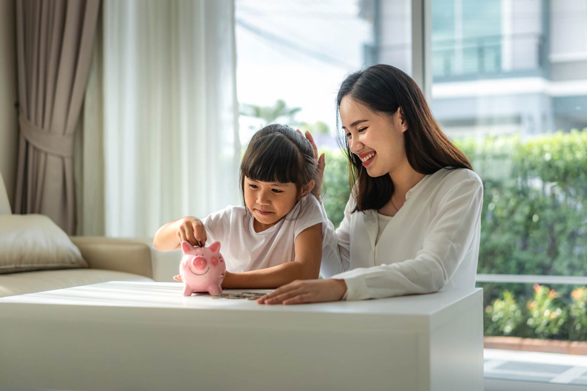 Mother with child using piggy bank — Jacksonville, FL — Beaches Family Law Mother with child using piggy bank — Jacksonville, FL — Beaches Family Law