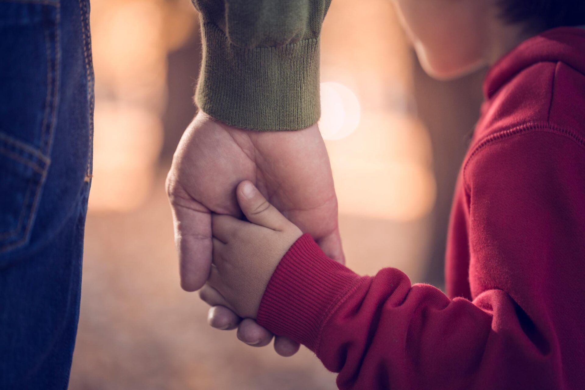Parent holding child in red hoodie's hand — Jacksonville, FL — Beaches Family Law Parent holding child in red hoodie's hand — Jacksonville, FL — Beaches Family Law