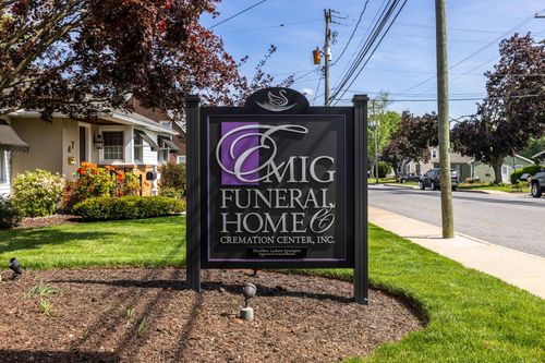 Emig Funeral Home sign beside a sidewalk in a suburban neighborhood