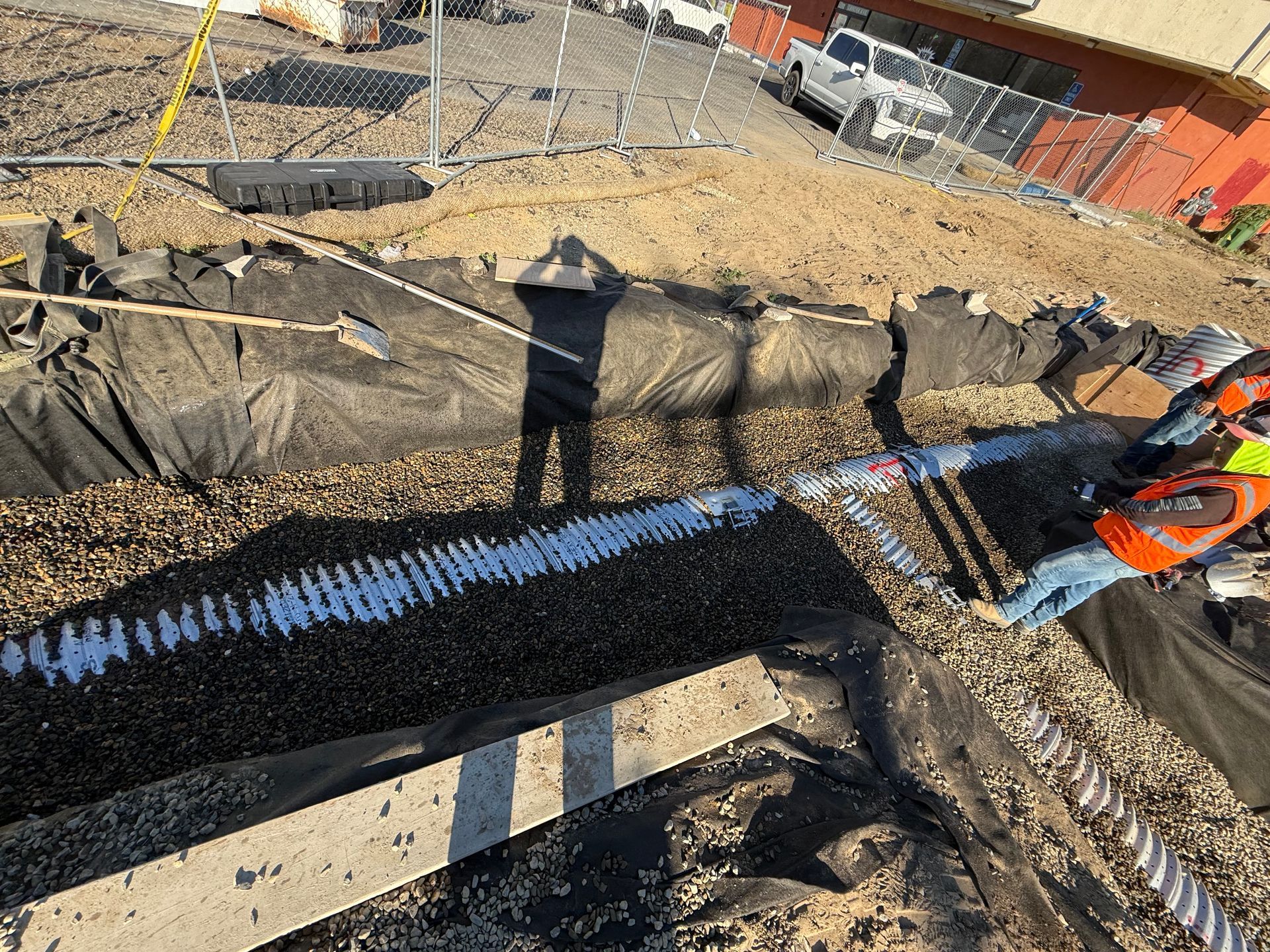 Plastic pipes and fittings installed in a rocky trench during excavation work