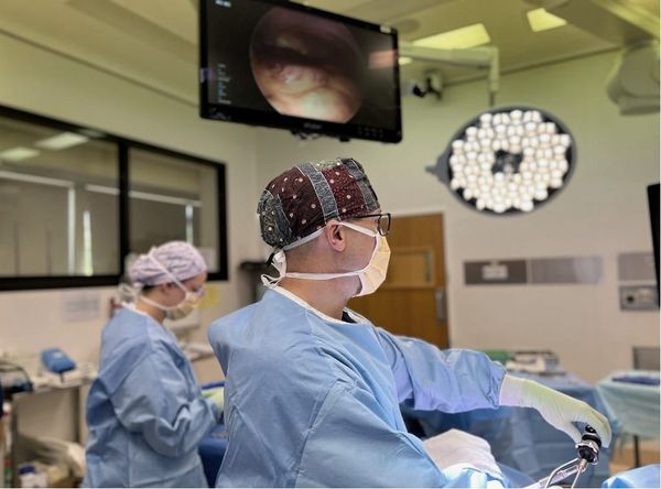 A group of surgeons are performing surgery in an operating room.