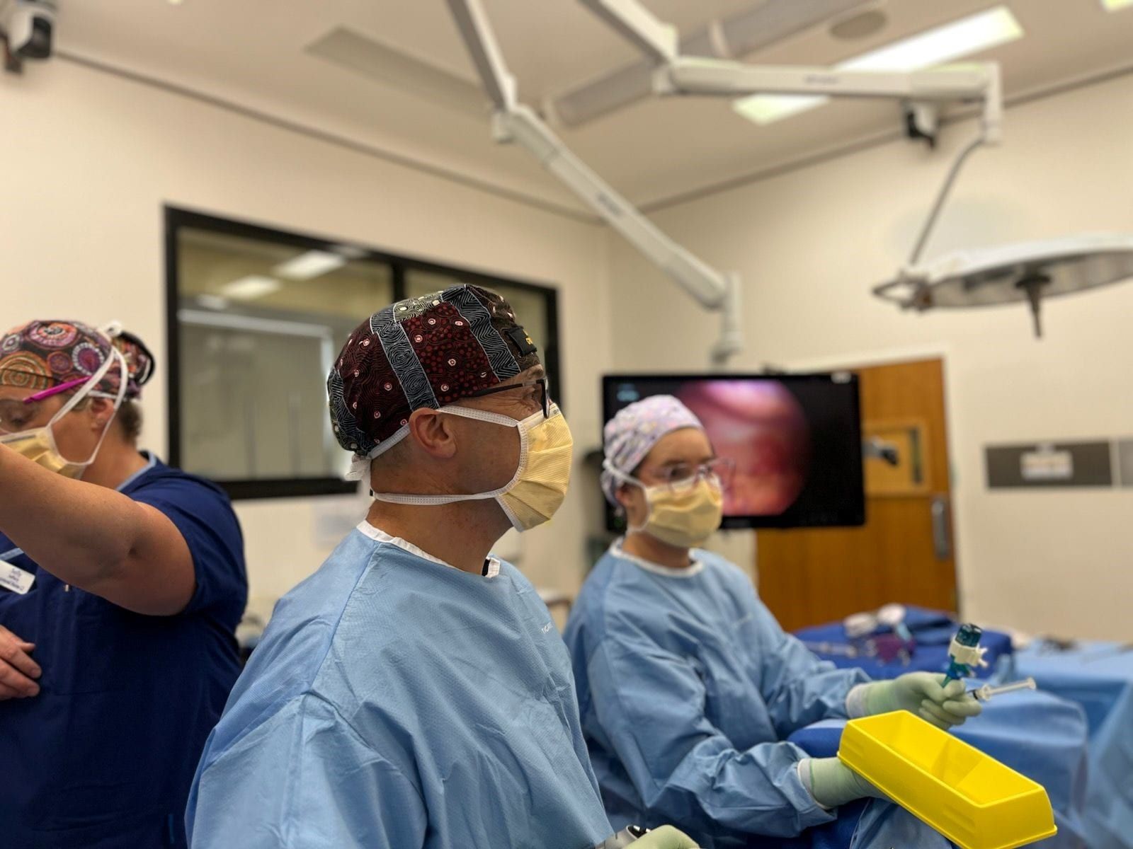 A group of surgeons are operating on a patient in an operating room.