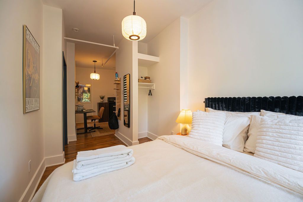 a small room with a desk , chair , lamp and mirror .