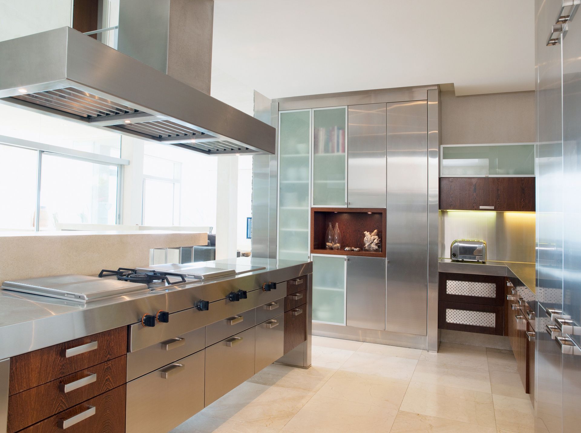 Modern stainless steel kitchen with sleek cabinetry, island cooktop, and range hood.