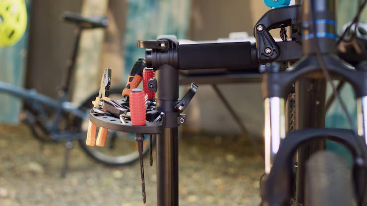 Un vélo est en train d'être réparé sur un support avec des outils.