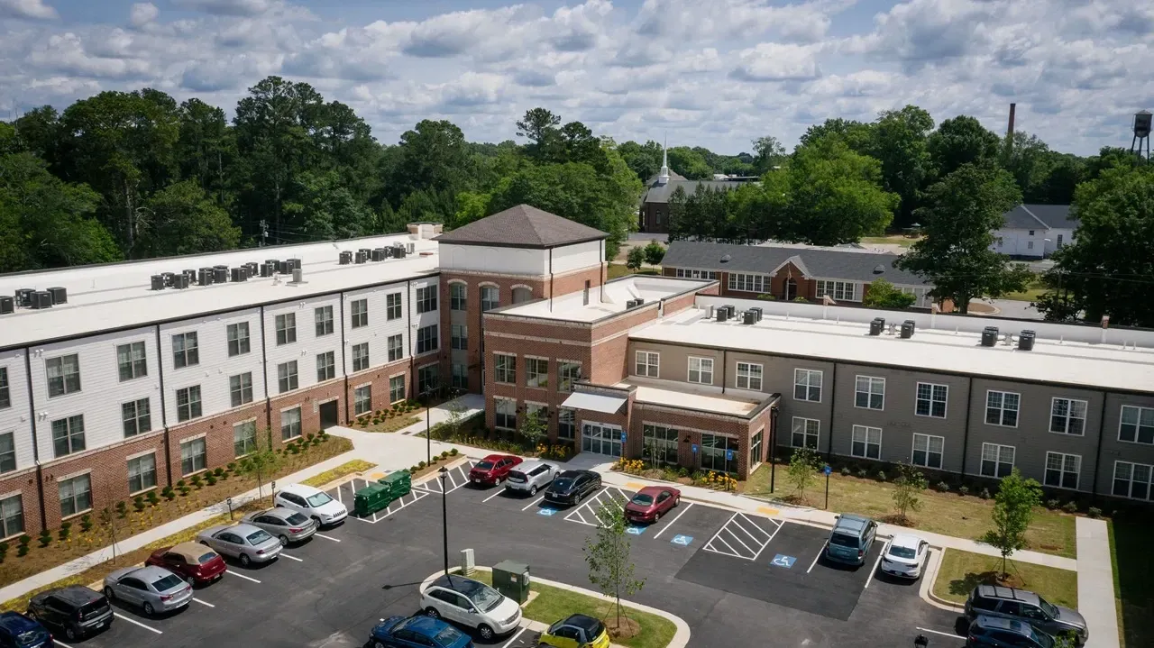 Aerial view of a modern apartment complex's exterior and parking lot.