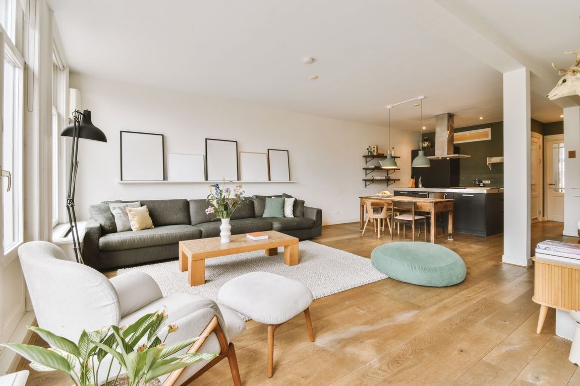 A living room with a couch, chair, coffee table and ottoman.
