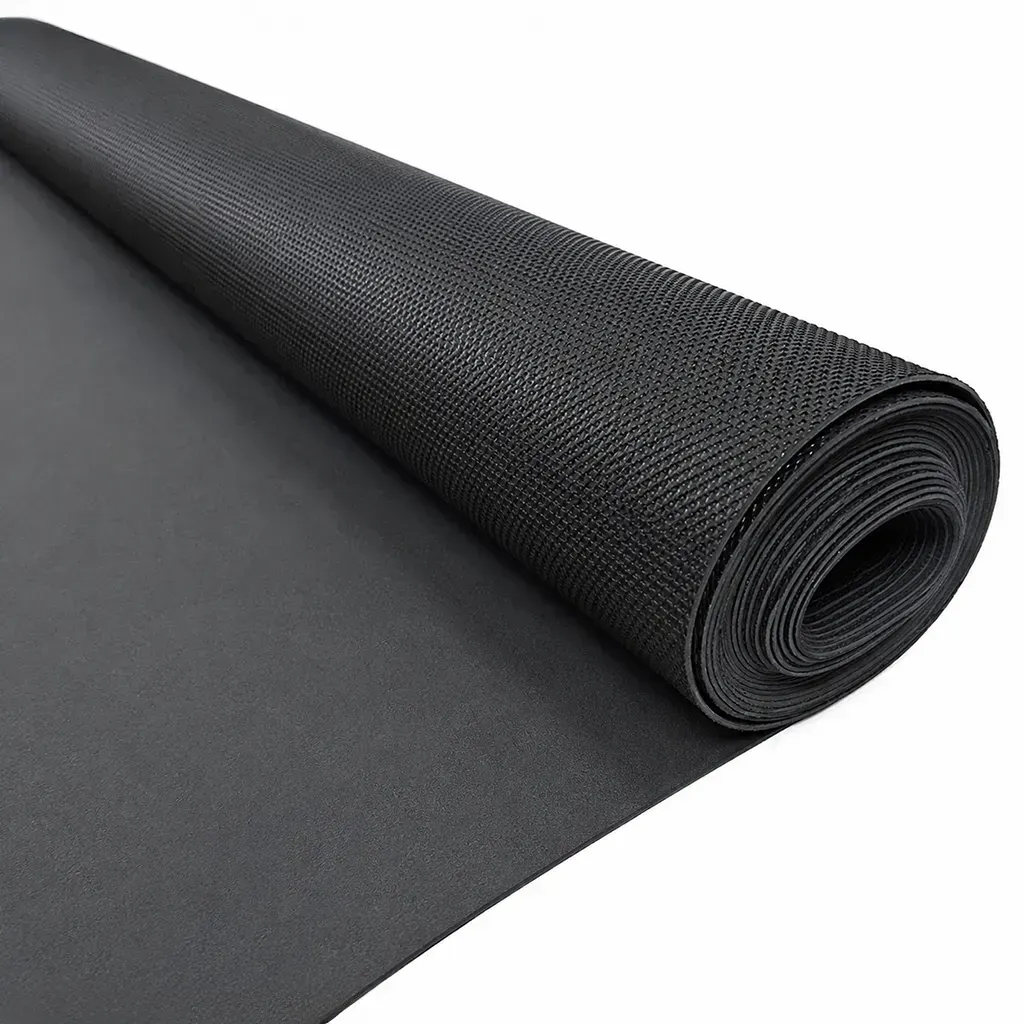 Esterilla de yoga negra texturizada enrollada sobre una superficie gris.