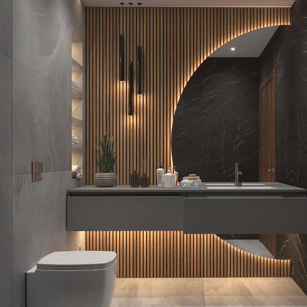 Baño moderno con pared de listones de madera, tocador flotante, lavabo, espejo e inodoro bajo iluminación cálida.