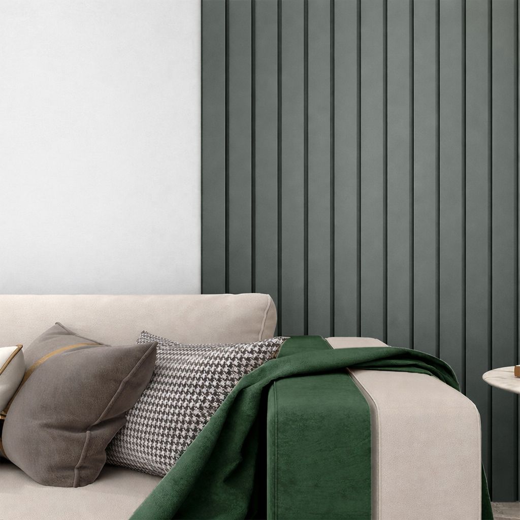 Sala de estar moderna con sofá beige, cojines estampados, manta verde y paneles verticales oscuros en la pared.