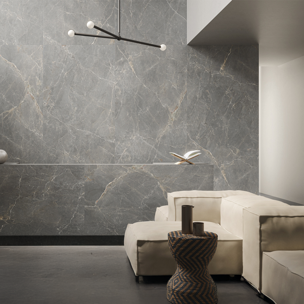 Baño moderno de color gris con ducha de cristal, inodoro blanco, estanterías negras y ventana con persianas.
