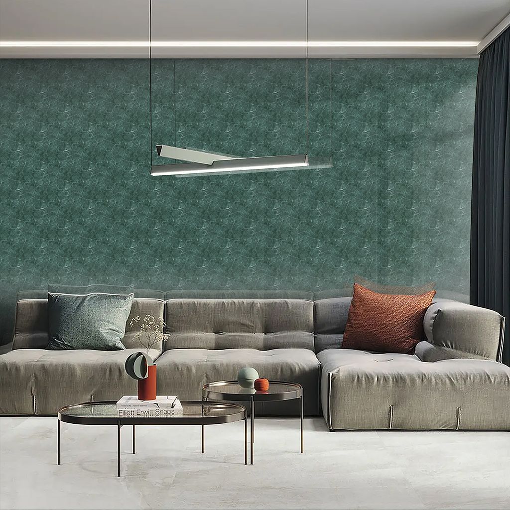 Sala de estar moderna con sofá modular gris, pared texturizada verde, lámpara colgante y mesas de centro de cristal.