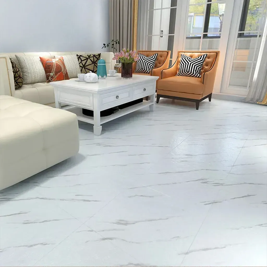 Sala de estar luminosa con sofá blanco, mesa de centro blanca, sillas naranjas y grandes ventanales con cortinas.