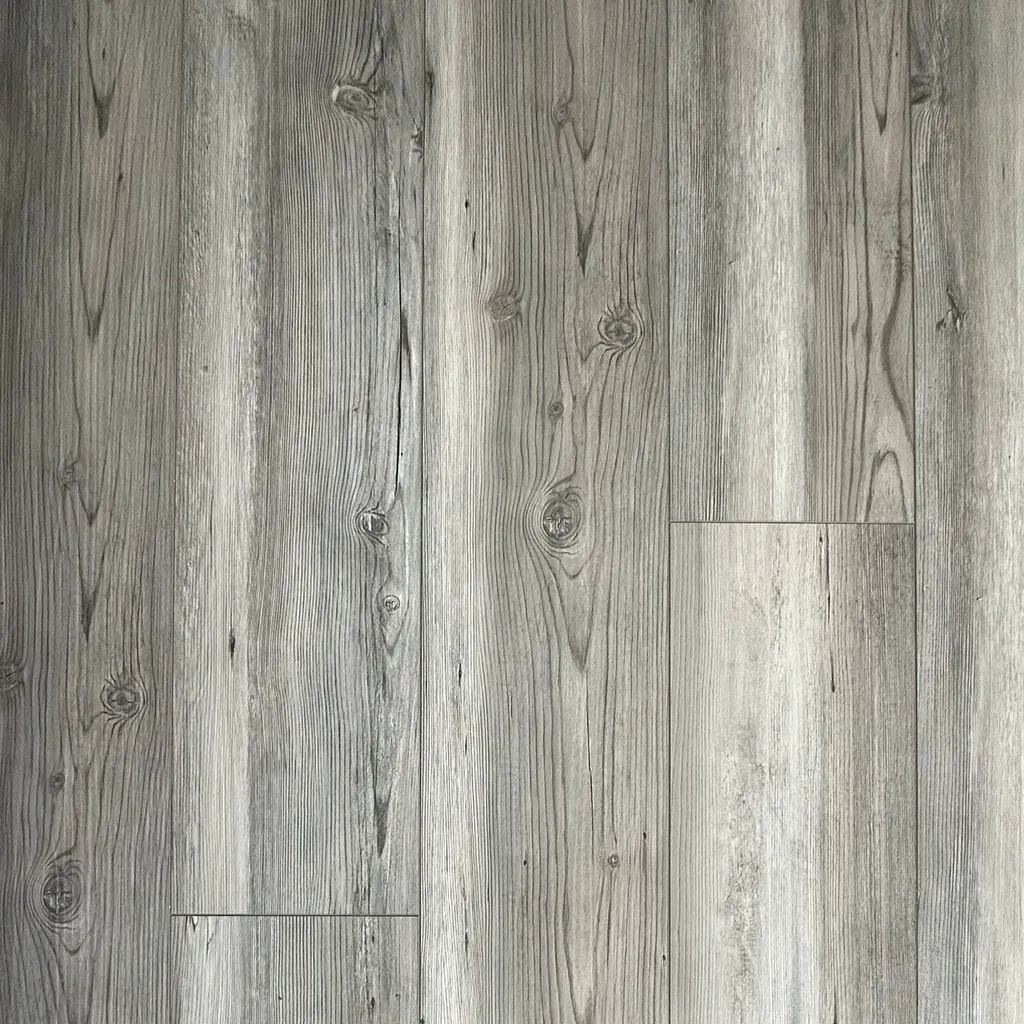 Suelo de tablones de madera gris con vetas variadas y algunas tablas rectangulares más claras.