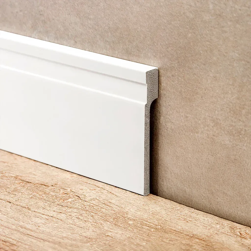Pasillo de color gris claro con puertas blancas, luces empotradas y una pequeña zona de estar en el extremo izquierdo.